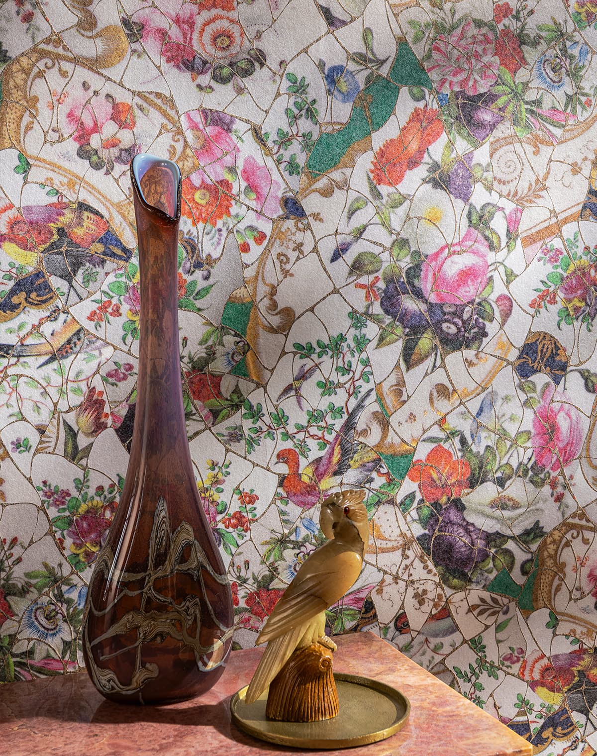 Eine Vase, eine Vogel-Dekofigur und eine Tapete mit floralem Design
