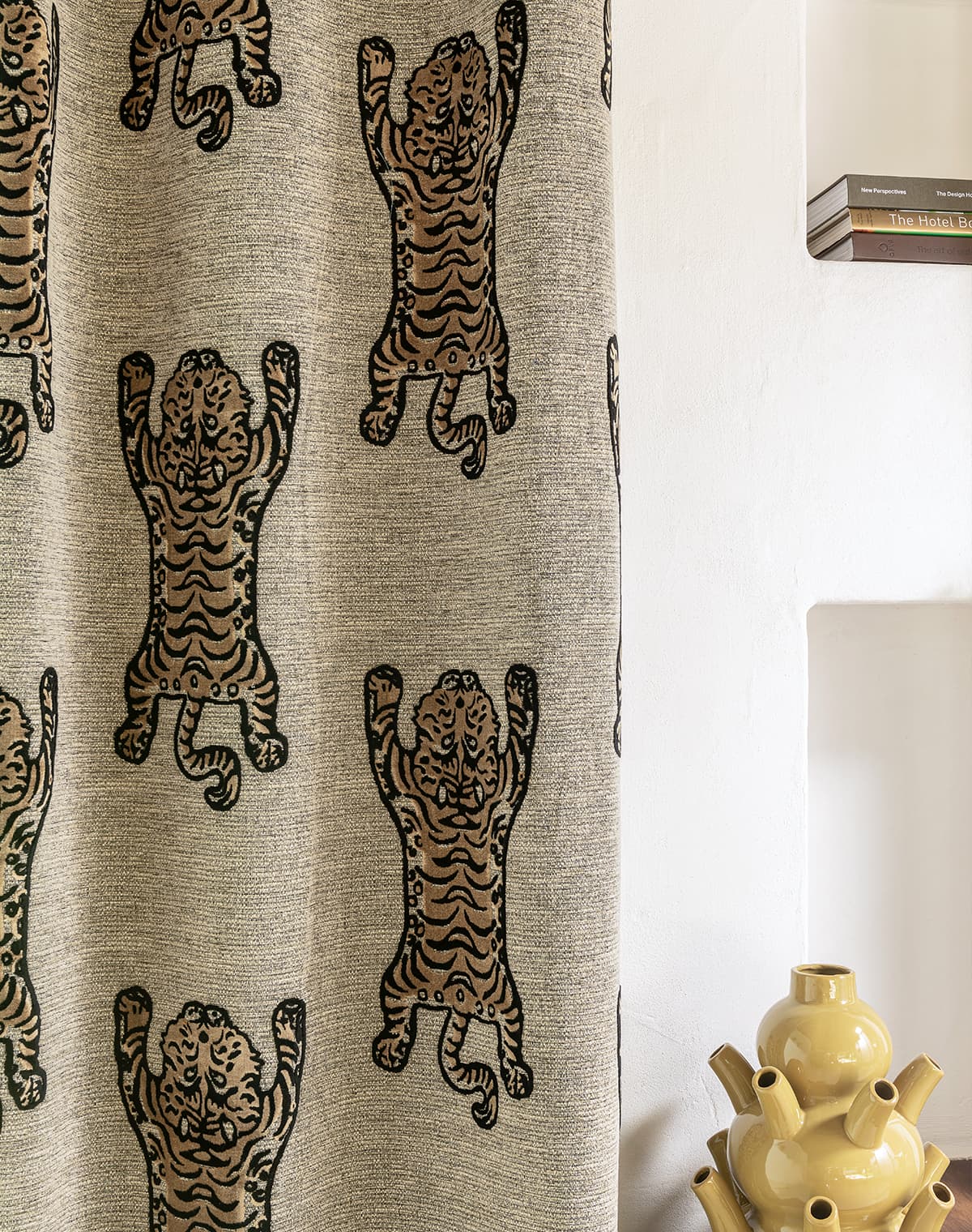 Grauer Vorhang mit Tiger-Print und eine gelbe Vase