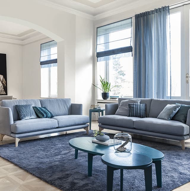 Zwei blaue Sofas in einem hellen weißen Raum mit blauen Details