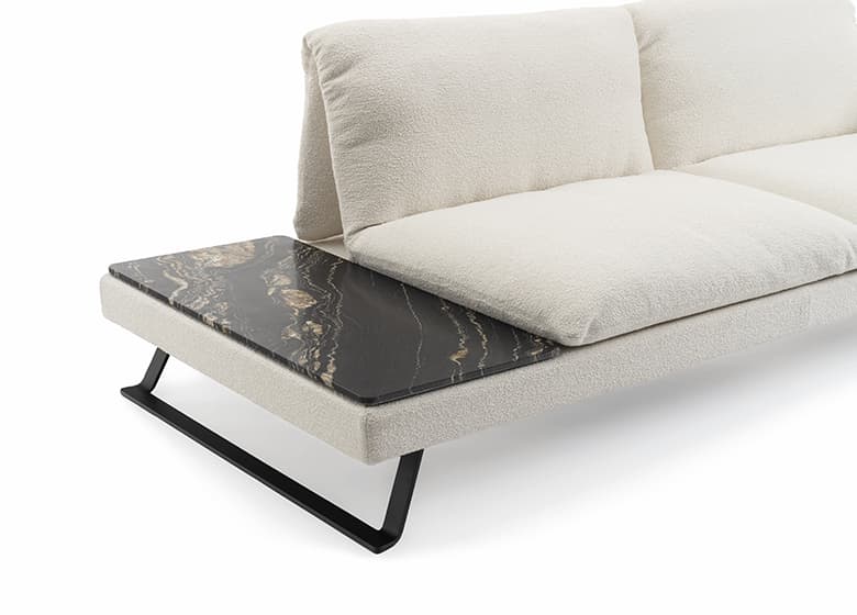 Nahaufnahe einer dunklen Quarzit-Tischoberfläche, welche an einem Sofa angebracht ist.