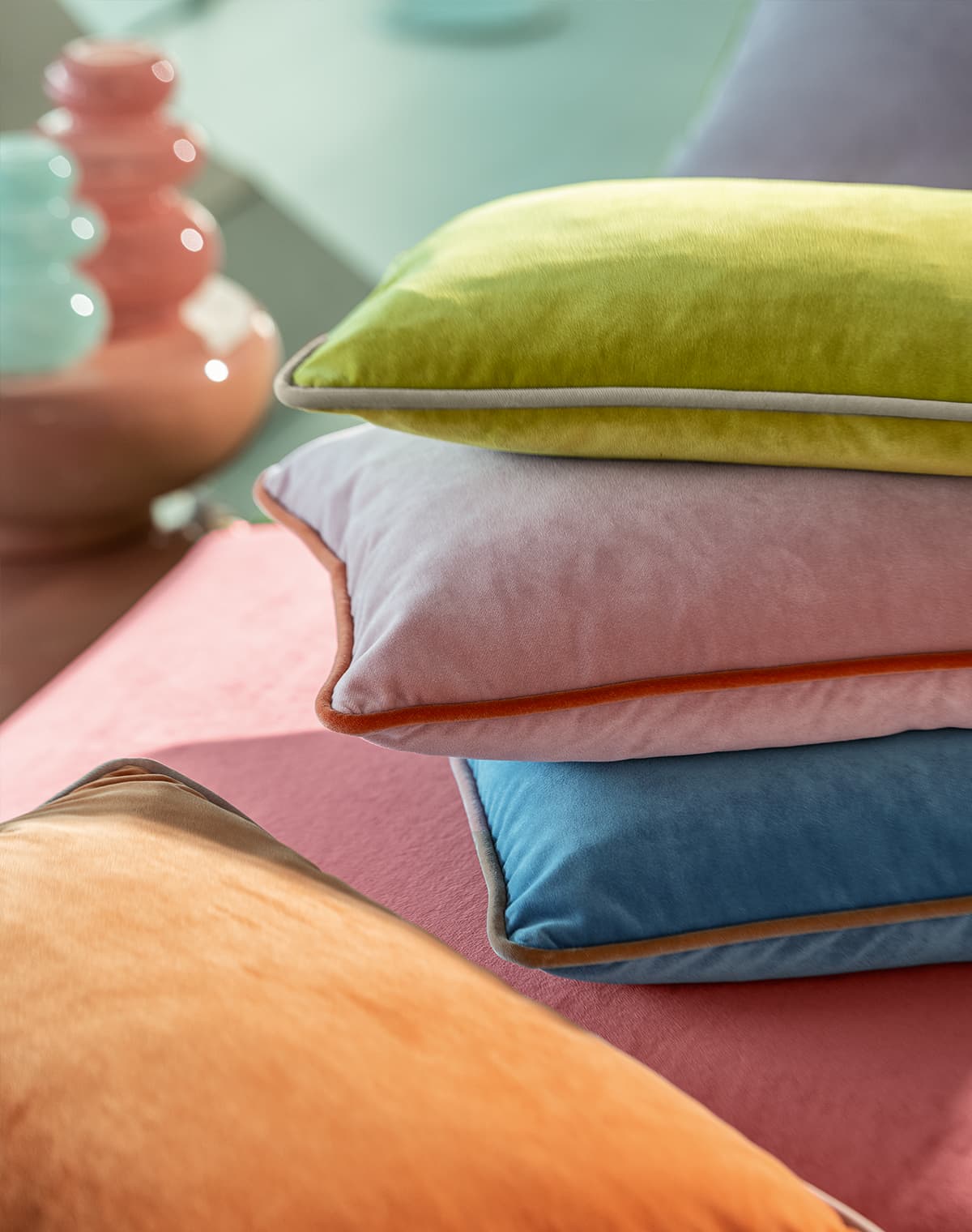 Kissen in rosa, grün, blau und orange.