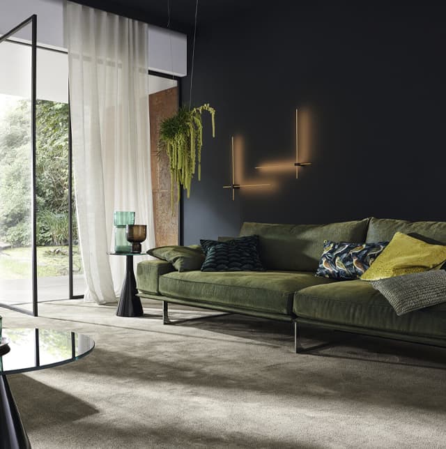 Wohnzimmer mit grünem Sofa und Teppichboden
