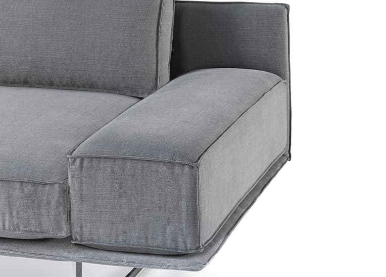 Freisteller einer Nahaufnahme einer Armlehne eines grauen Sofas
