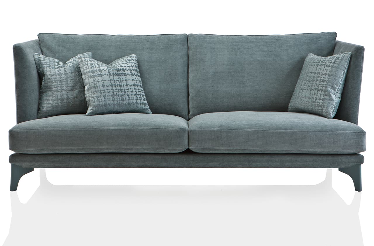 Freisteller eines grau-grünen Sofas mit Deko-Kissen. Die Arm- und Rückenlehne ist sehr hoch.