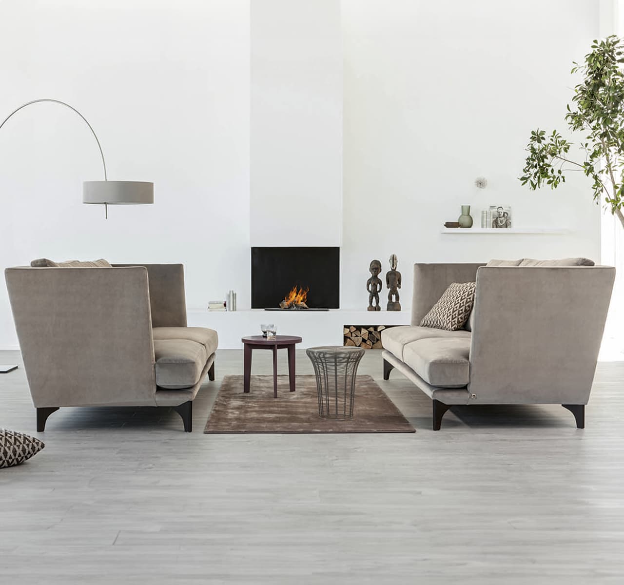 Zwei Sofas in Beige stehen sich gegenüber in einem hellen weißen Raum