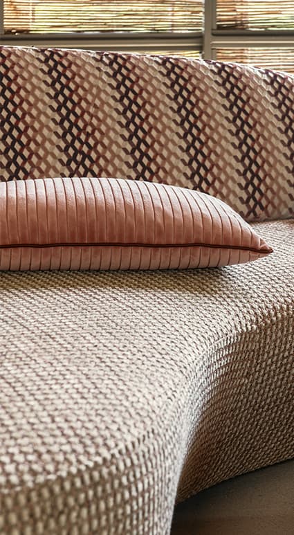 Mehrfarbig gemustertes Sofa mit rosa Kissen