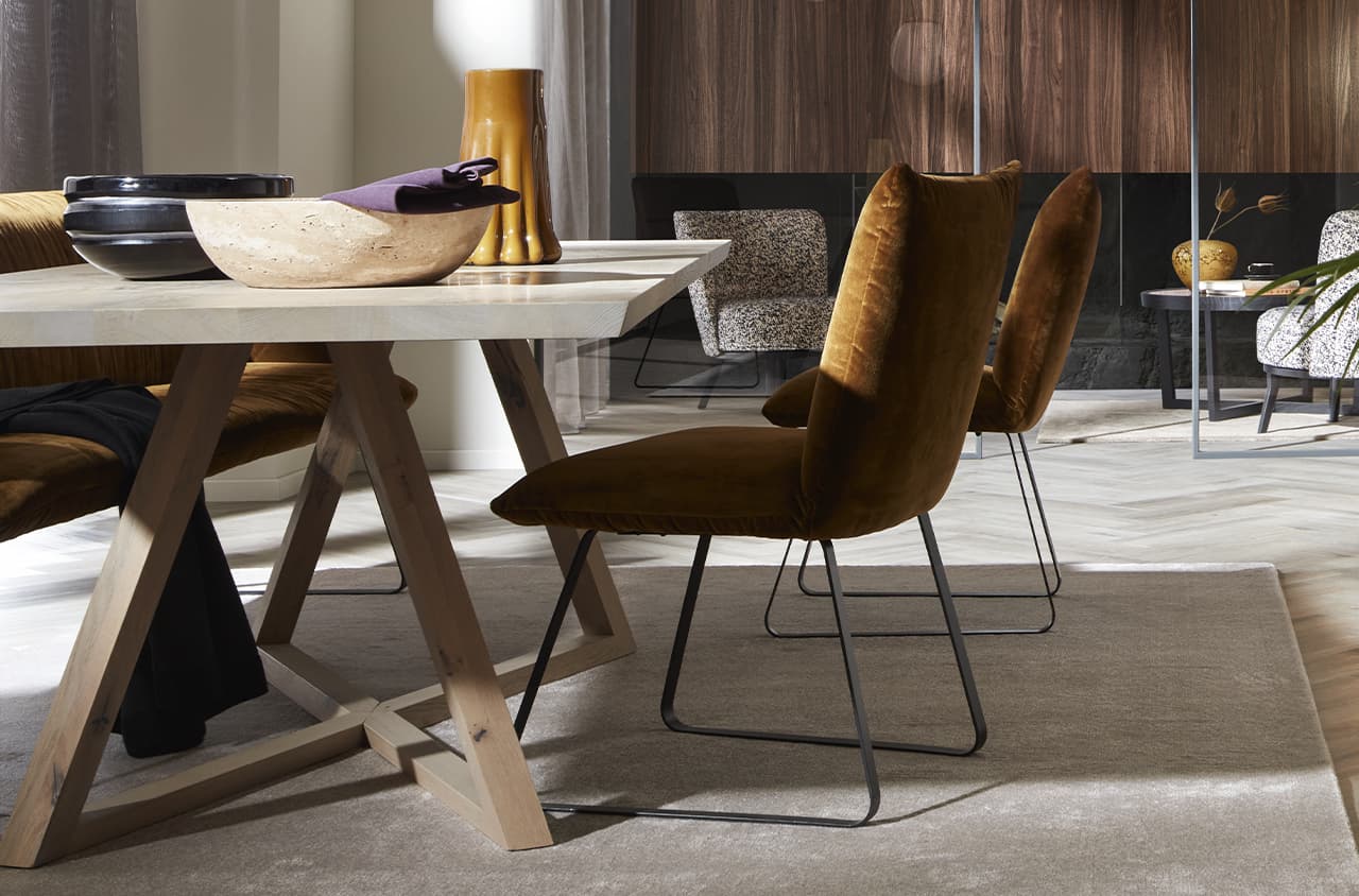 Braune Stühle um einen weißen Tisch auf einem grauen Teppich